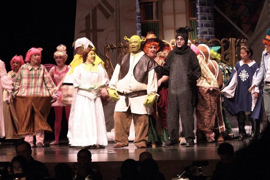 Princess Fiona (Taylor Sternberg), Shrek (Cries Cryer), and Donkey (Will Davis) sing happily with fairy tale creatures