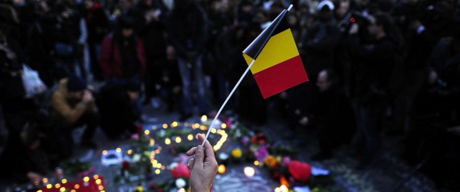 A local holds a paper national flag of Belgium at Beursplein square in honor of those who lost their lives (abcnews.go.com)